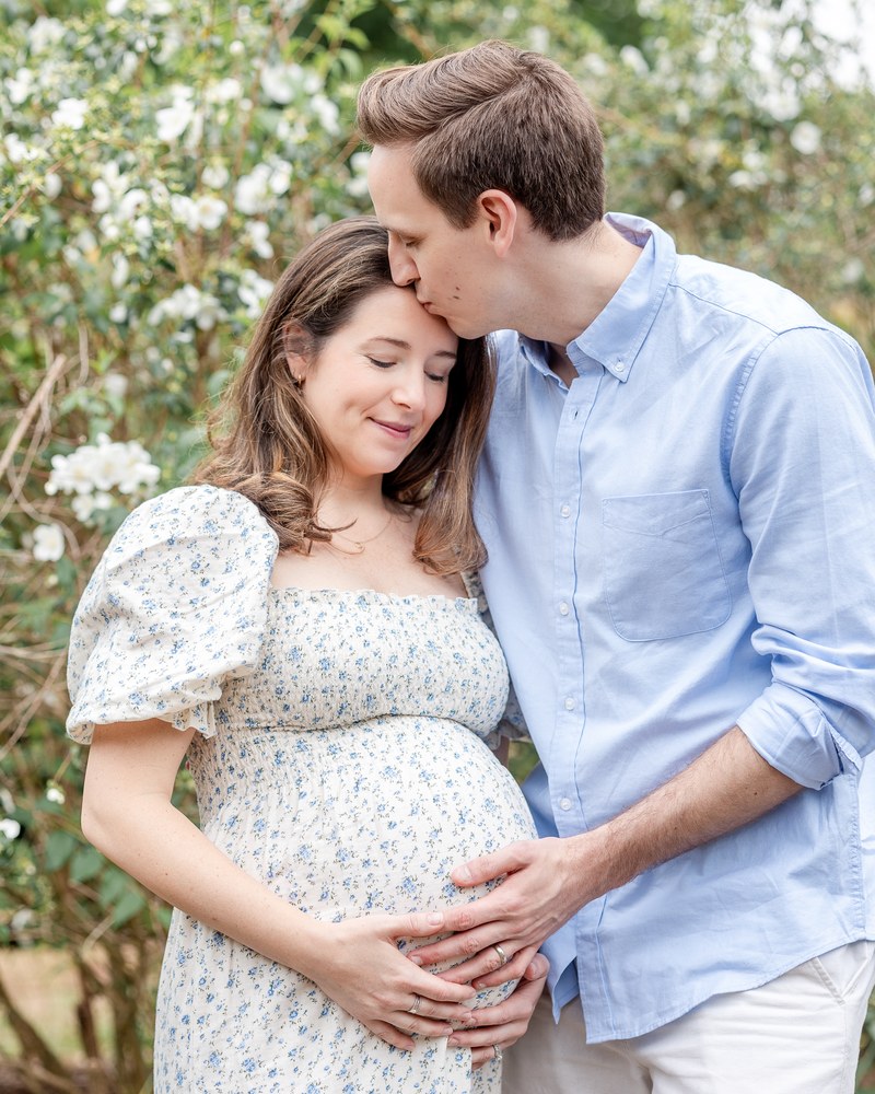 Expectant parents sharing a quiet moment in a spring garden